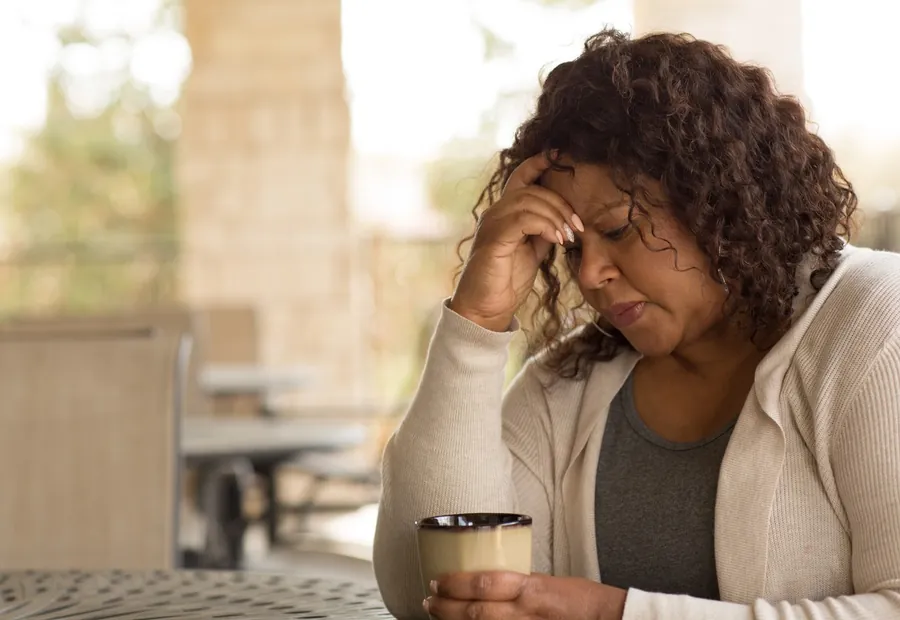 A worried woman holding a cup of tea